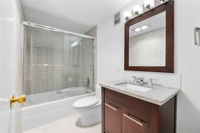 a bathroom with a bathtub shower sink vanity and toilet
