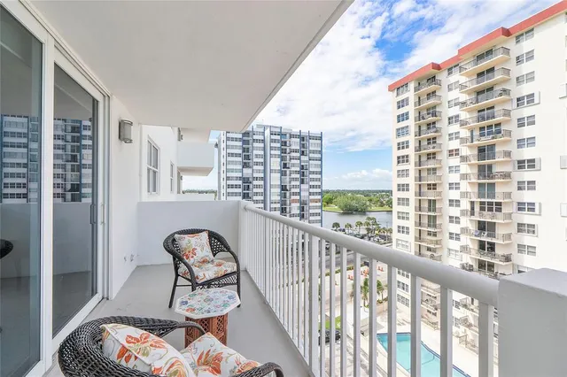 a view of a balcony with chairs and iron fence