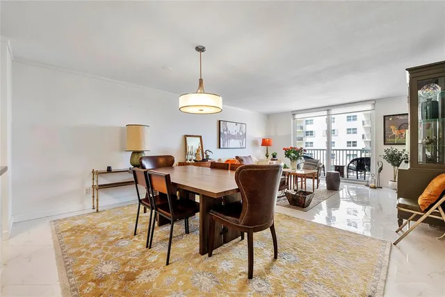 a view of a dining room and livingroom with furniture a rug a rug and a chandelier