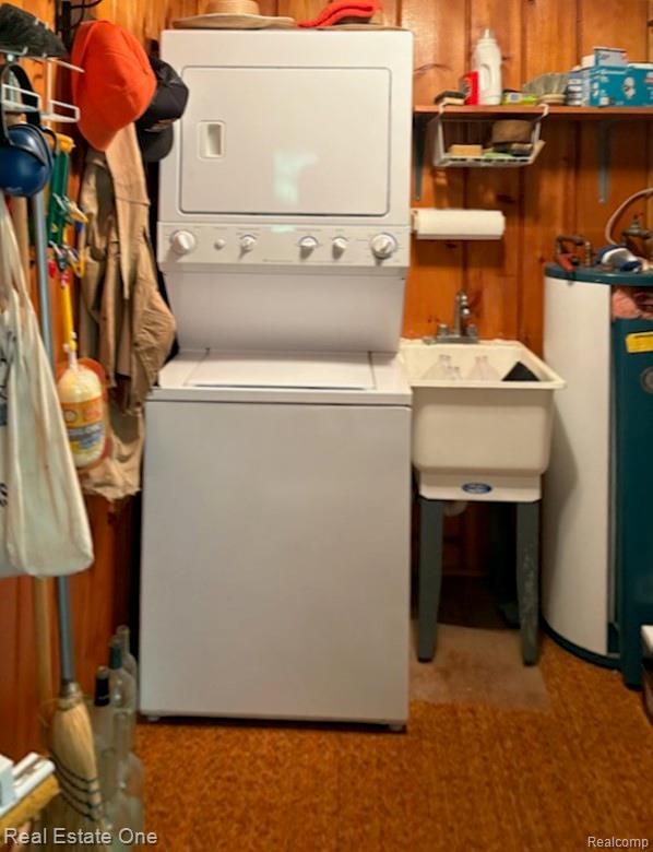 4233 Pheasant Road Lincoln, MI 48742 - Photo 11 of 19 Laundry area featuring stacked washer and dryer unit, utility sink, and a water heater