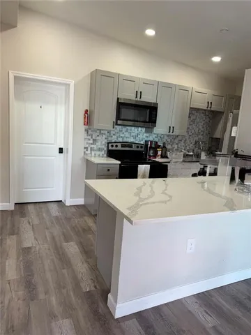 a view of kitchen with sink microwave and cabinets