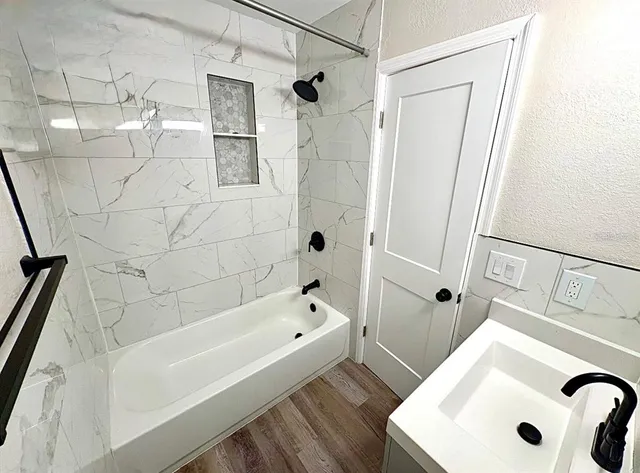 a bathroom with a tub a sink and a shower