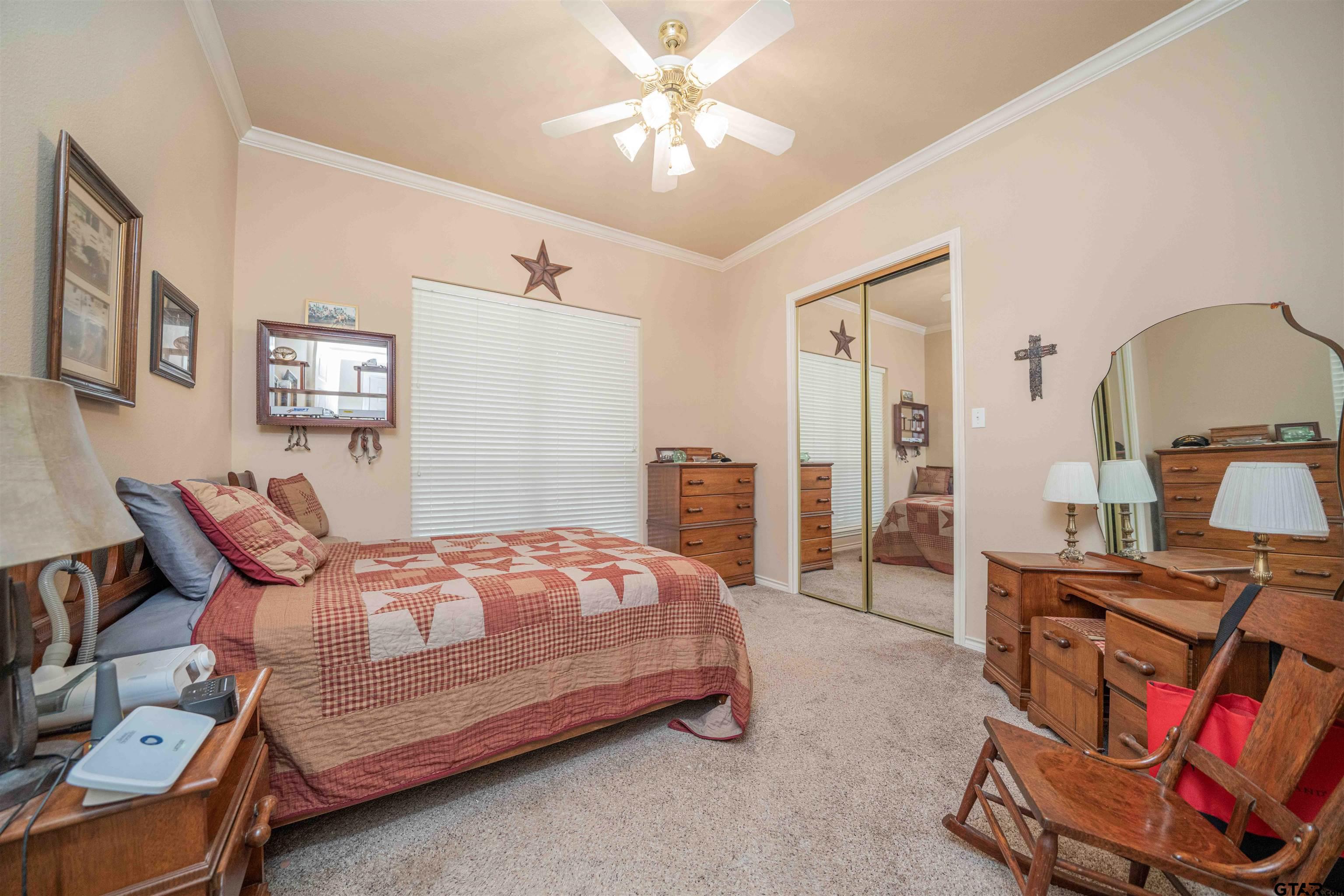 2215 Homestead Lane Tyler, TX 75701 - Photo 18 of 31 a bedroom with a bed and a chandelier