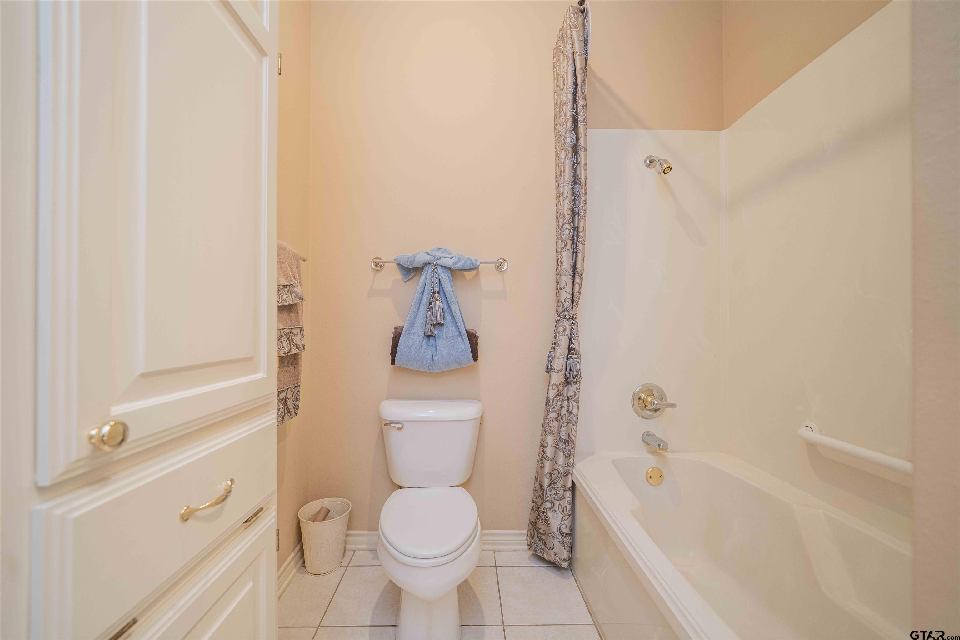 2215 Homestead Lane Tyler, TX 75701 - Photo 20 of 31 a bathroom with a toilet and a bathtub