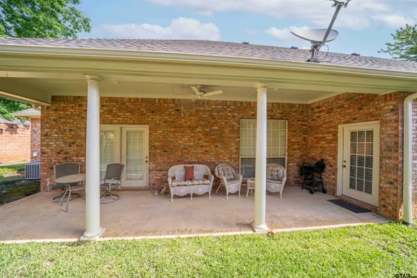 a bench is sitting in front of a brick house with large windows