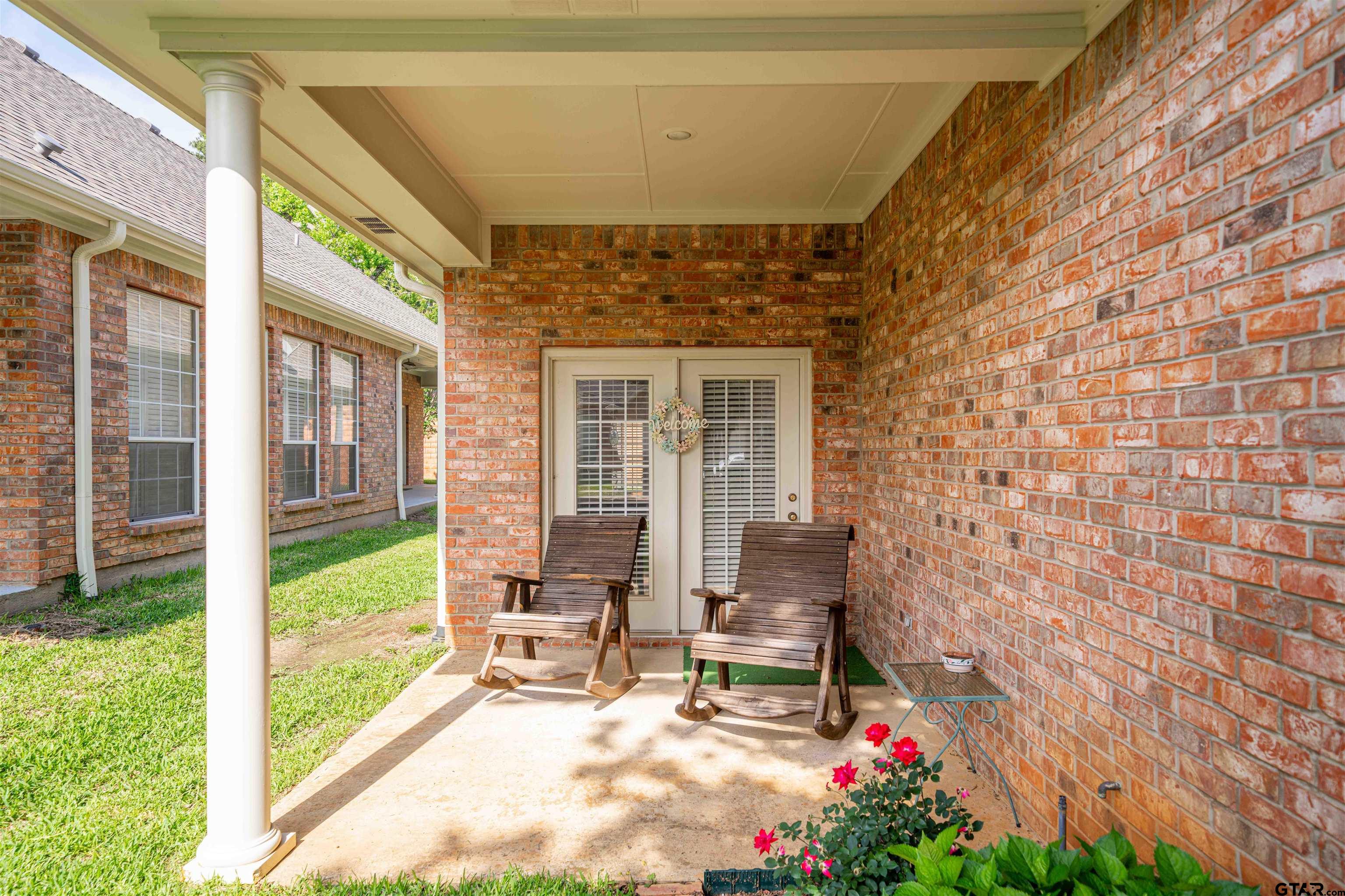 2215 Homestead Lane Tyler, TX 75701 - Photo 28 of 31 a bench is sitting in front of a brick house with large windows