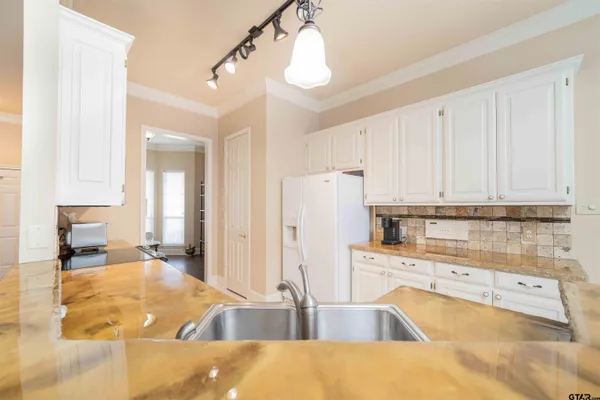 a kitchen with granite countertop a sink a stove top oven and cabinets