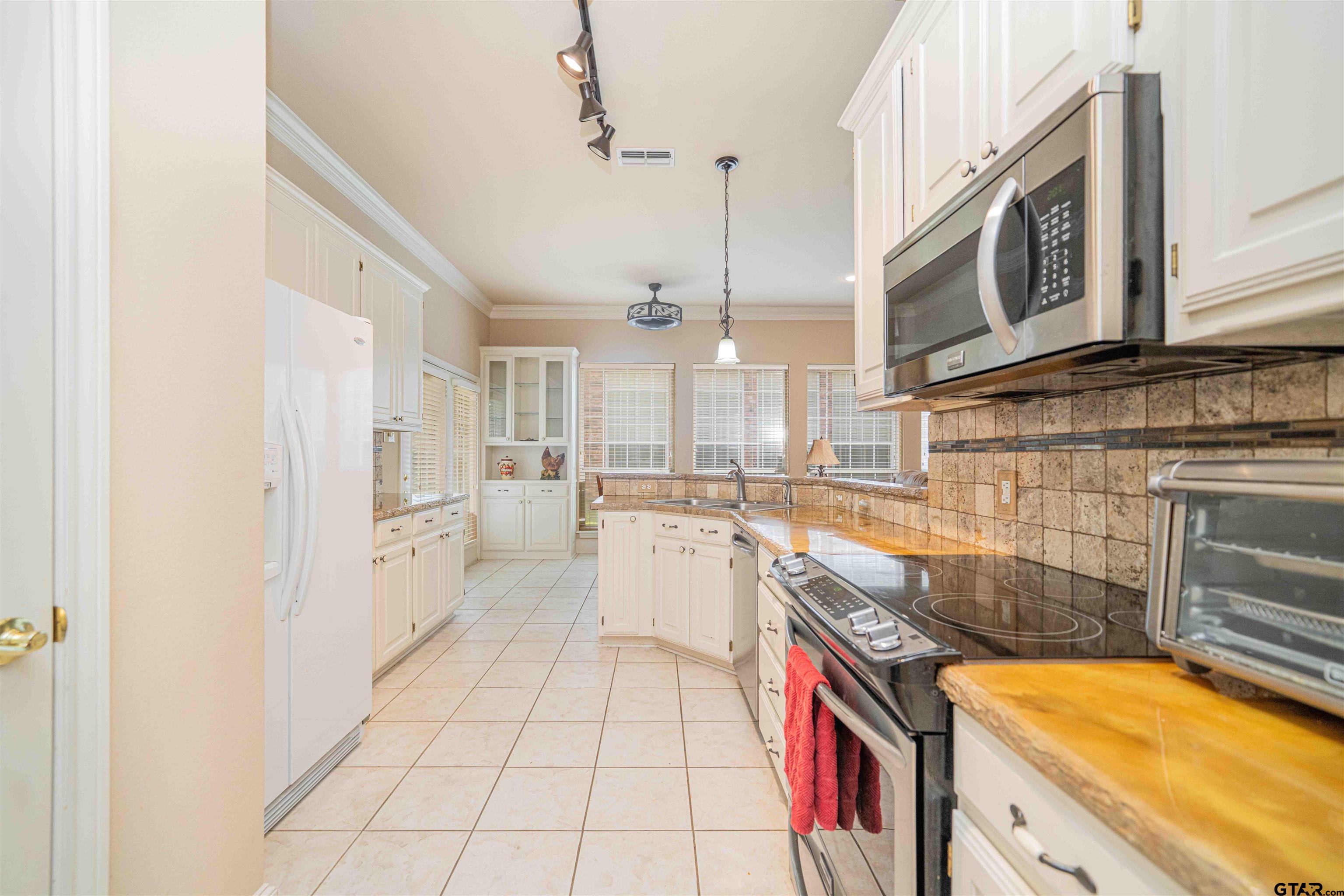 2215 Homestead Lane Tyler, TX 75701 - Photo 10 of 31 a kitchen with a sink stove and cabinets