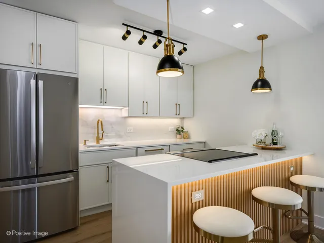 a kitchen with a sink a stove and chairs