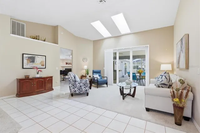 a living room with furniture and a large window with balcony view