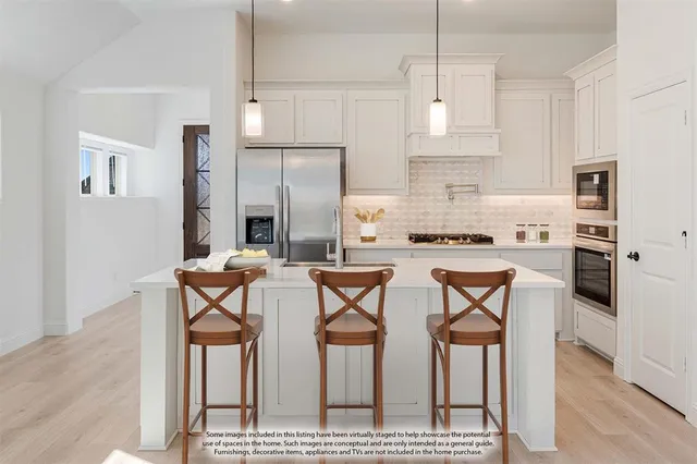 a kitchen with white cabinets and refrigerator
