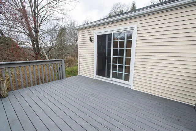 a view of backyard with a deck and wooden floor