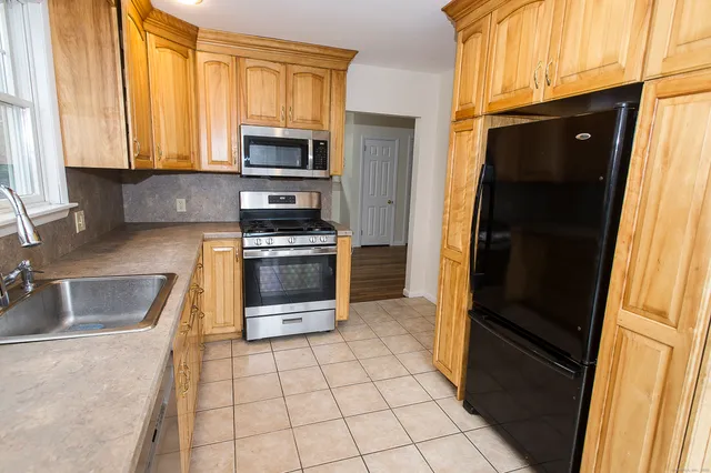 a kitchen with granite countertop a refrigerator and a sink