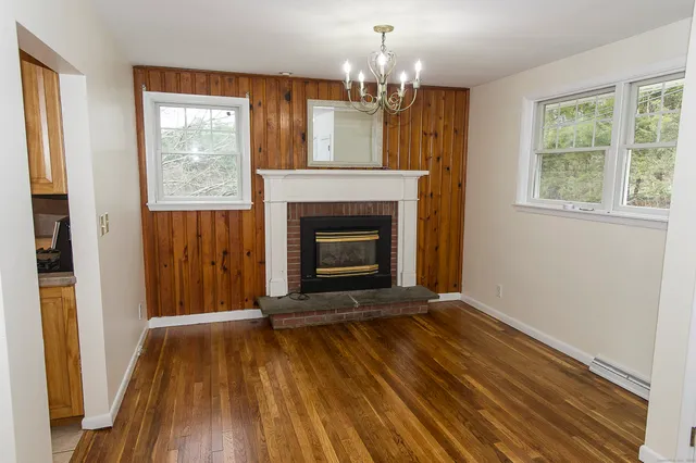 wooden floor fireplace and windows in an empty room