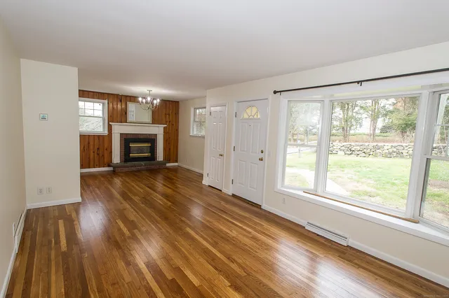 a view of empty room with wooden floor and fireplace