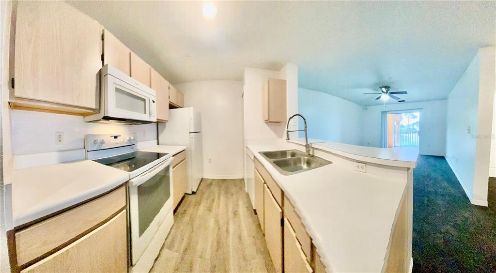 5459 Vineland Road, Unit 4210 Orlando, FL 32811 - Photo 16 of 25 a kitchen with a sink stove and cabinets