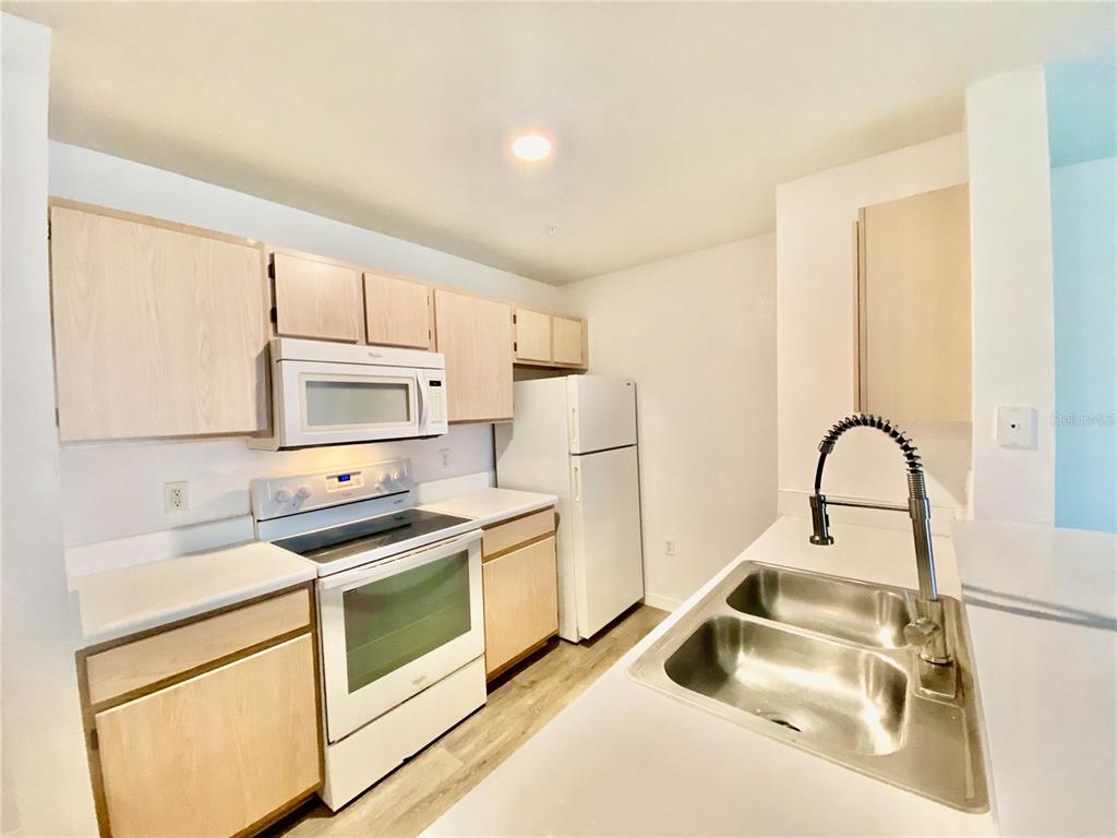 5459 Vineland Road, Unit 4210 Orlando, FL 32811 - Photo 17 of 25 a kitchen with stainless steel appliances a sink stove and refrigerator