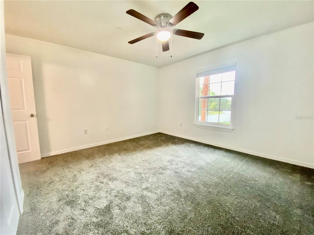 5459 Vineland Road, Unit 4210 Orlando, FL 32811 - Photo 24 of 25 an empty room with a window and a ceiling fan