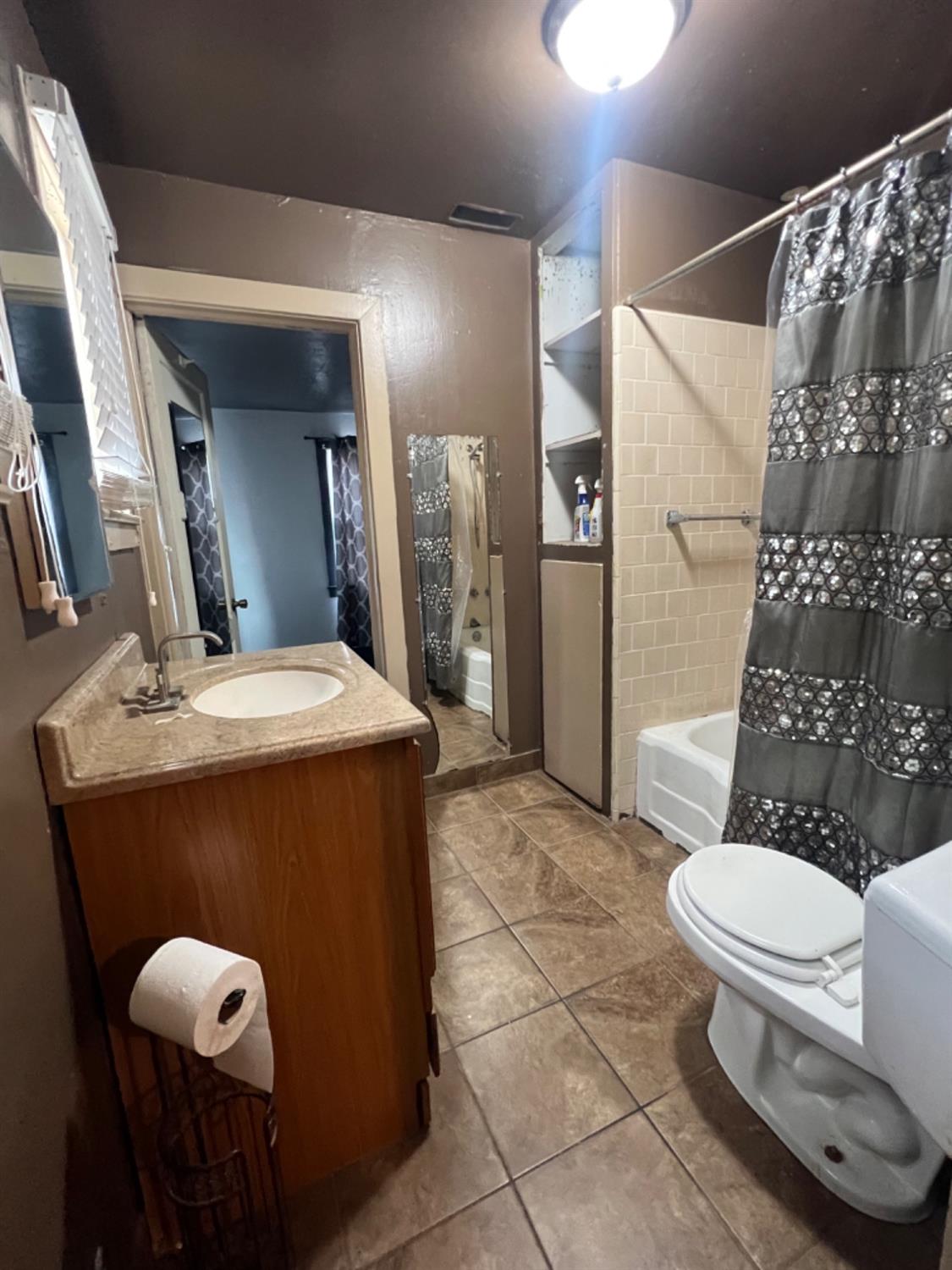 47 West Olive Avenue Madera, CA 93637 - Photo 4 of 10 a bathroom with a toilet sink shower and mirror