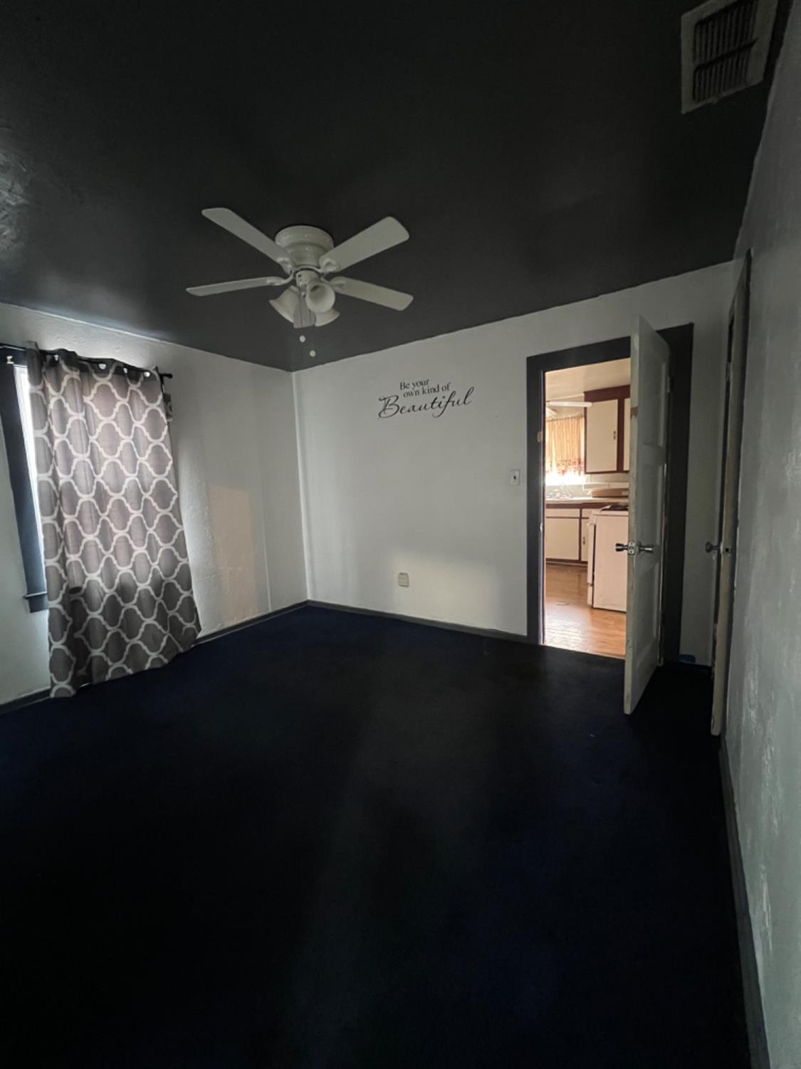 47 West Olive Avenue Madera, CA 93637 - Photo 5 of 10 a view of an empty room with a ceiling fan and a window