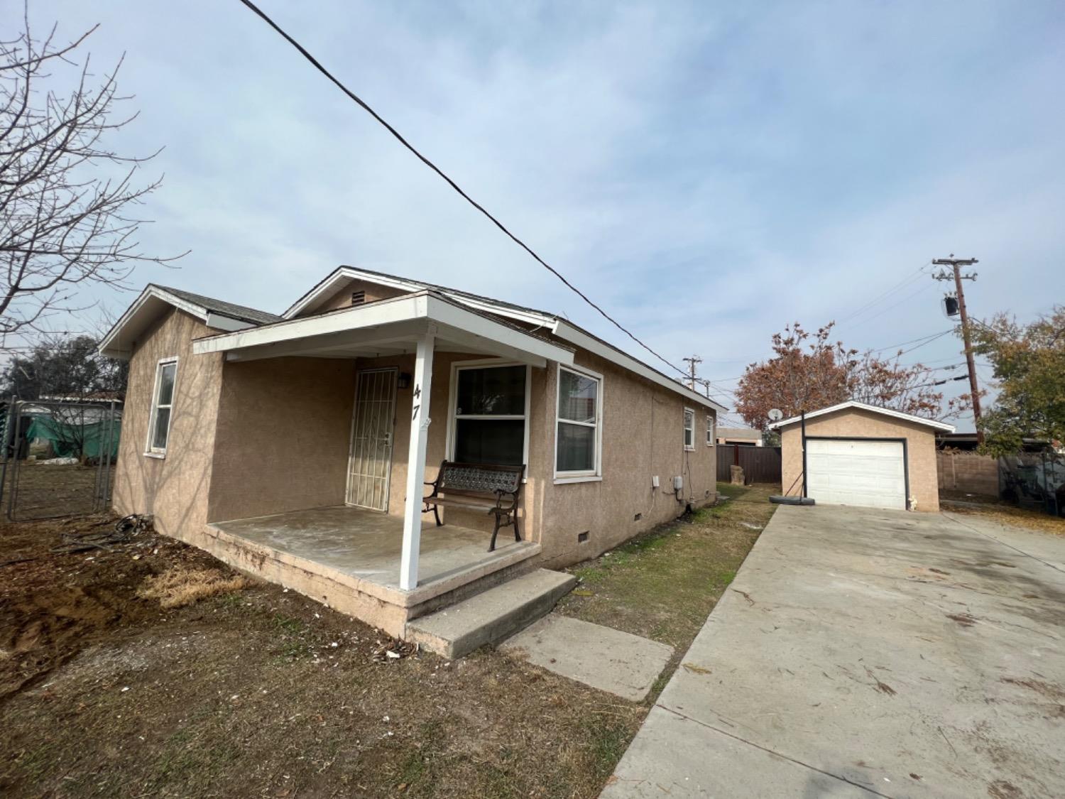 47 West Olive Avenue Madera, CA 93637 - Photo 8 of 10 a front view of a house with a yard and garage