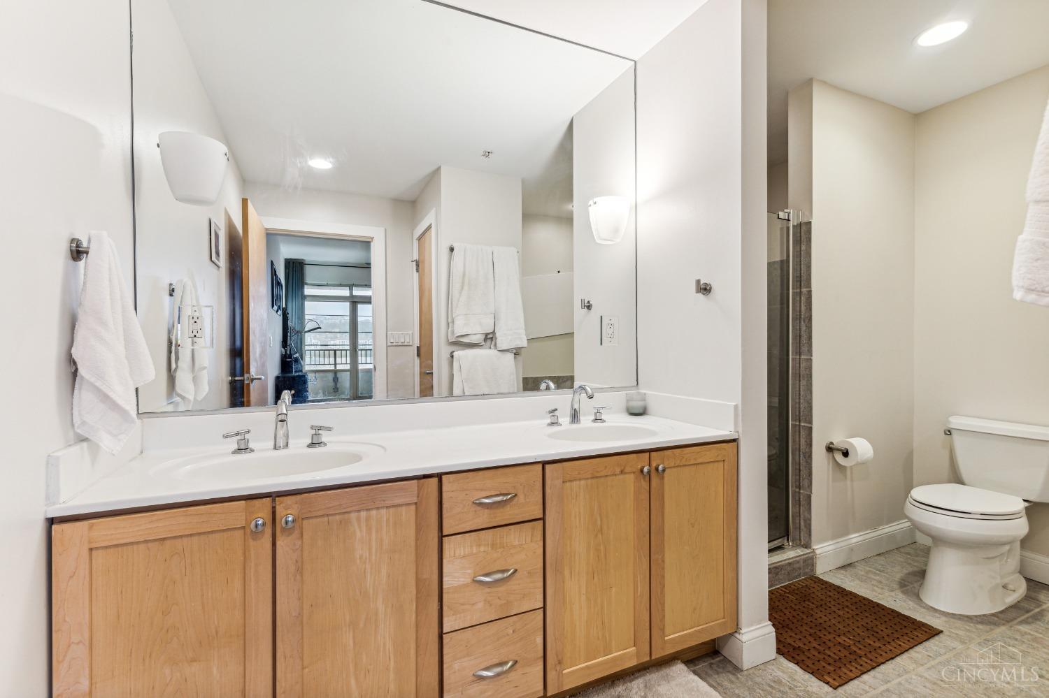 2260 Riverside Drive, Unit 205 Cincinnati, OH 45202 - Photo 25 of 37 The Primary bath features double sinks, Kohler fixturing, Italian glass sconce lighting, a soaking tub and separate shower, clad in smoky grey porcelain tile...a true spa-like experience...