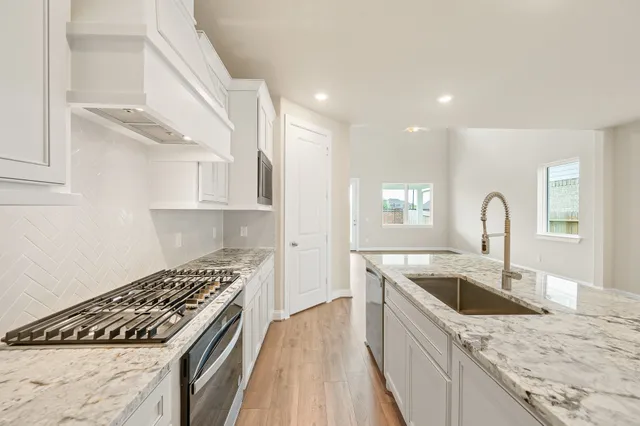 a kitchen with a stove sink and cabinets