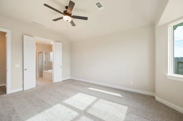 an empty room with fan and windows