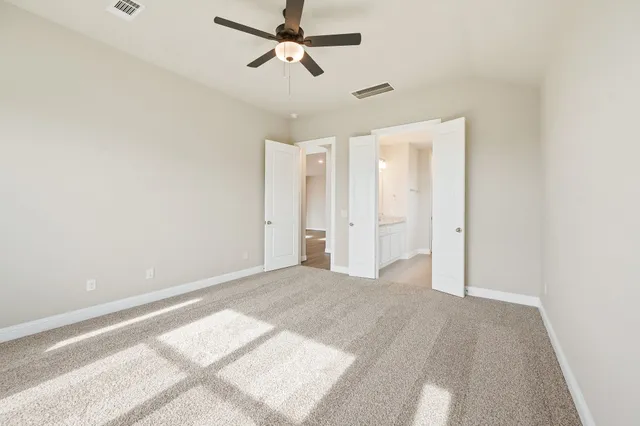 a view of a room with a ceiling fan and window