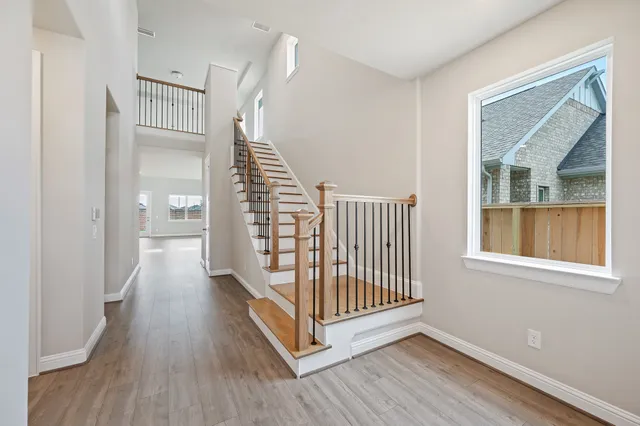 a view of a hallway with wooden floor and windows