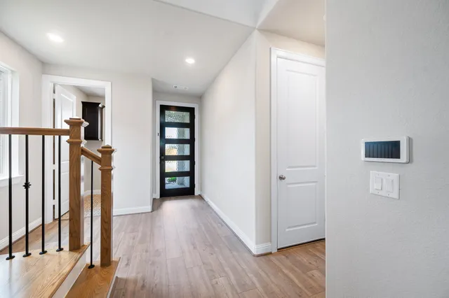 a view of a hallway with wooden floor and closet