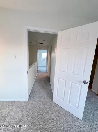 a view of a hallway to rooms