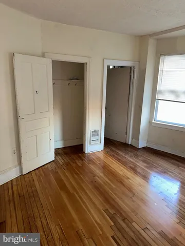 a view of empty room with wooden floor