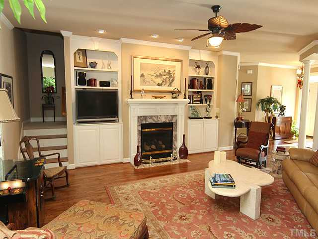 Spacious family room has gas log fireplace and built-in bookshelves for display Den/Family/Great Room