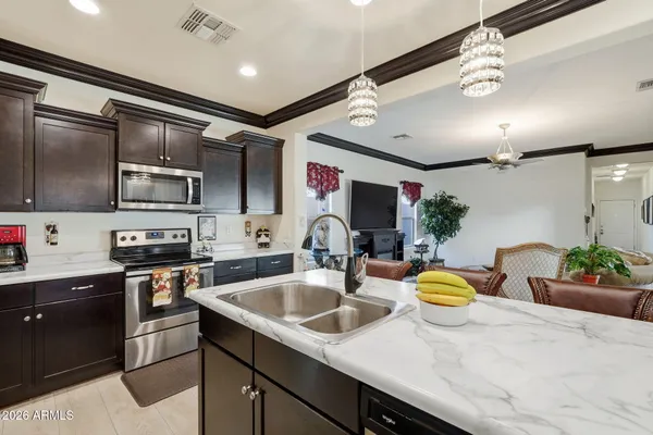 a kitchen with a sink stainless steel appliances and dining table