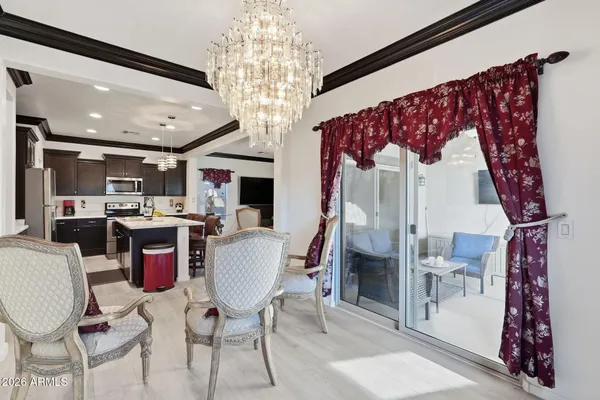 a view of a dining room with furniture a chandelier and window