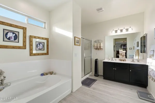 a spacious bathroom with a tub sink and mirror