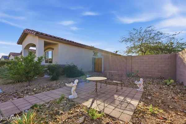 a backyard of a house with table and chairs