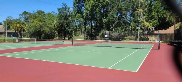 a sign broad in front of the green tree