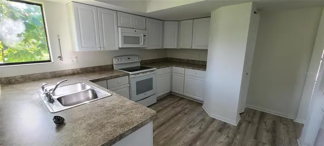 a kitchen with a stove window and cabinets