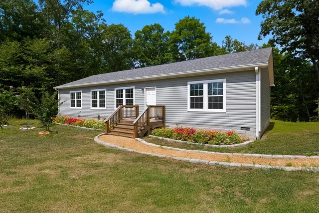 a view of a house with backyard and trees