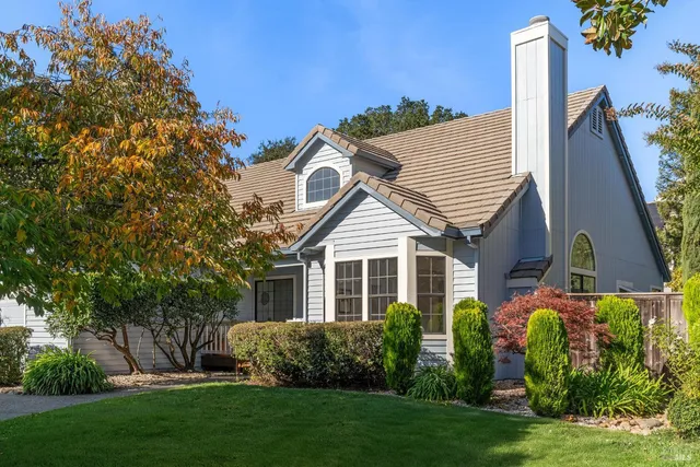front view of house with a yard and potted plants