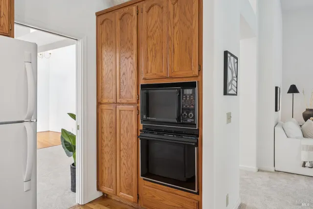 a living room with furniture kitchen view and a wooden floor