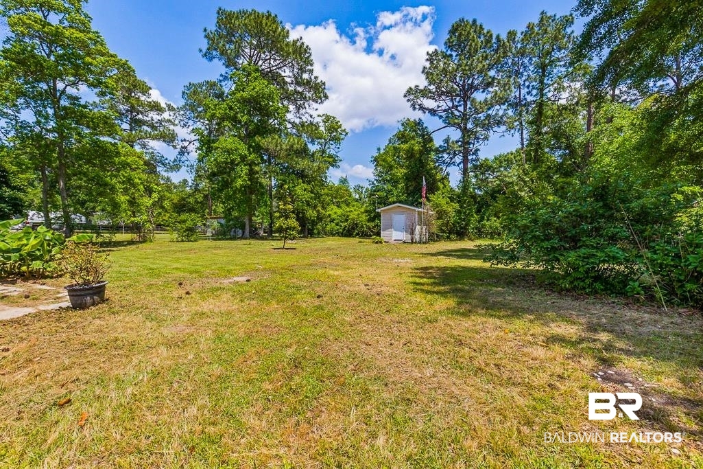 1301 Repoll Road Mobile, AL 36695 - Photo 20 of 21 Expansive yard featuring mature trees and a detached shed