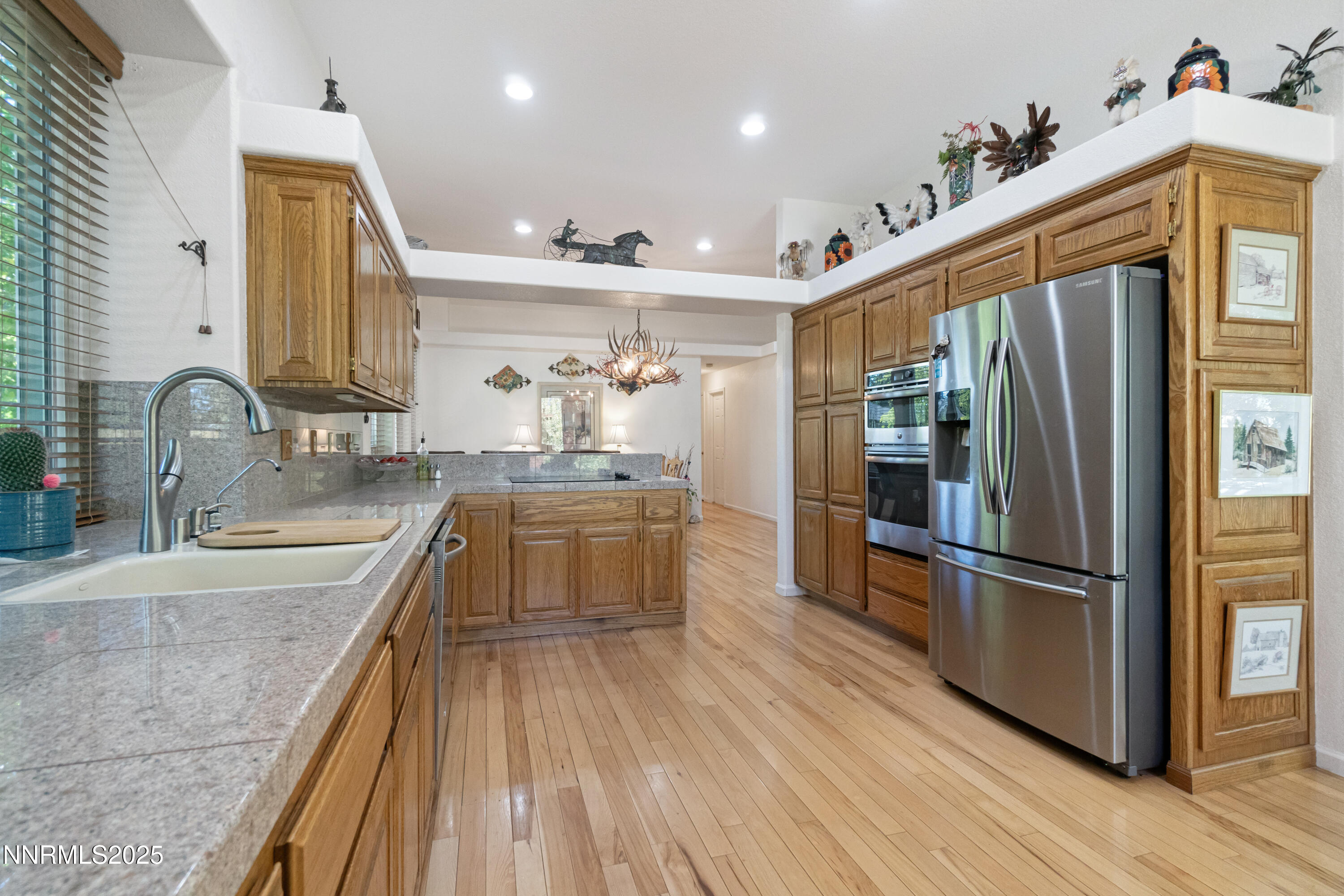 1216 Pleasantview Drive Gardnerville, NV 89460 - Photo 12 of 32 a kitchen with stainless steel appliances granite countertop a refrigerator a sink dishwasher and a stove with wooden floor