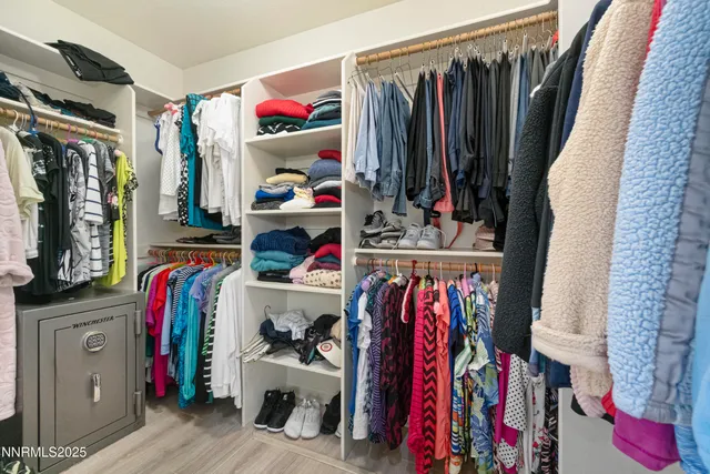 a view of walk in closet with clothes
