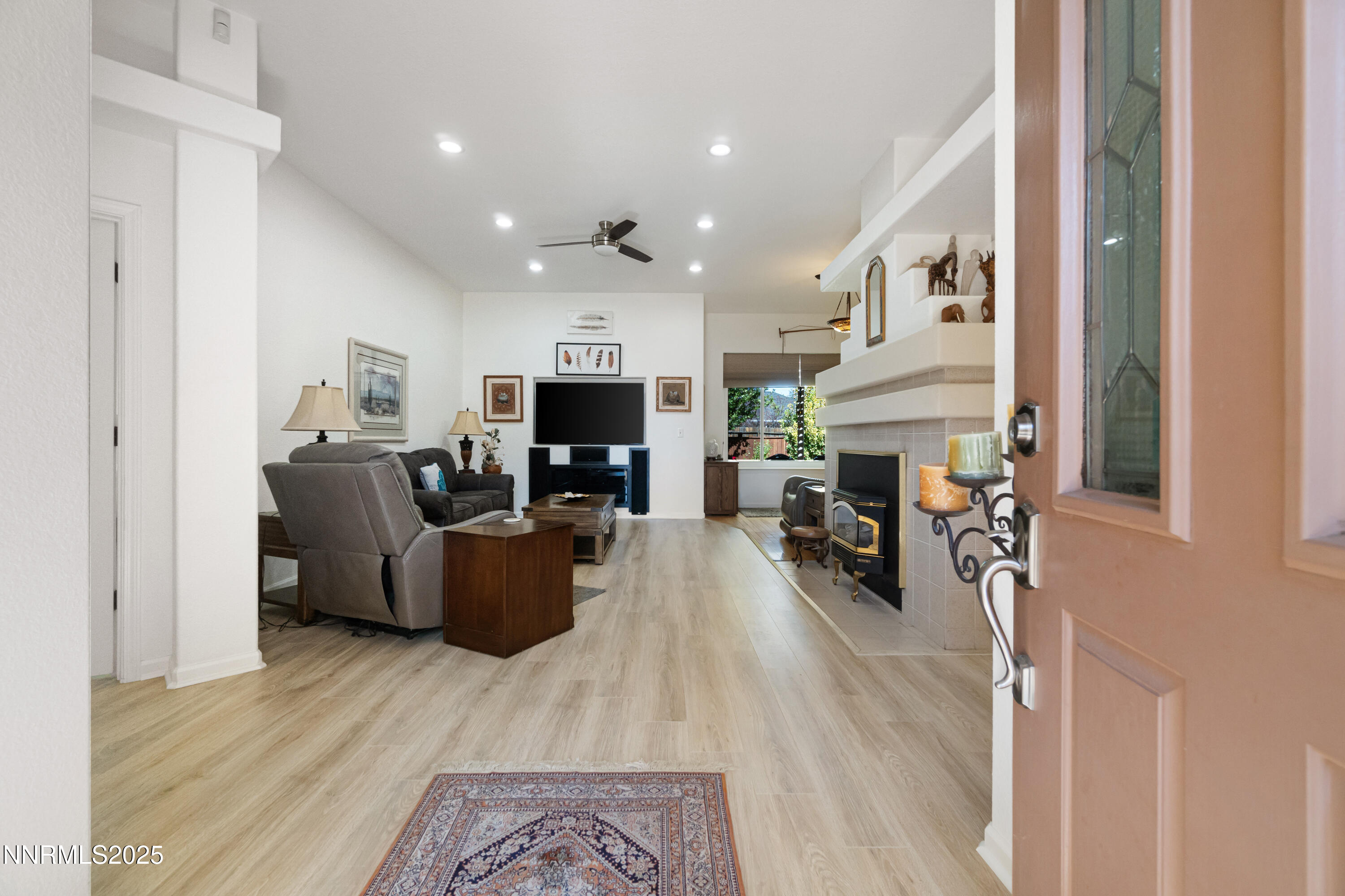1216 Pleasantview Drive Gardnerville, NV 89460 - Photo 5 of 32 a living room with furniture a fireplace and a flat screen tv