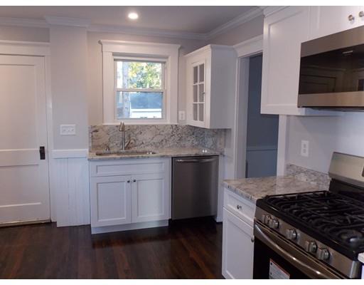 10 Fulton Street Woburn, MA 01801 - Photo 5 of 34 a kitchen with granite countertop a stove a sink and a microwave