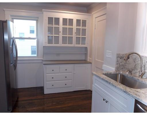 10 Fulton Street Woburn, MA 01801 - Photo 6 of 34 a kitchen with a granite countertop white cabinets and a sink