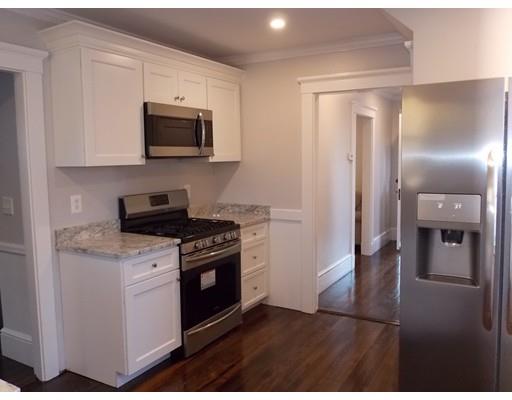 10 Fulton Street Woburn, MA 01801 - Photo 7 of 34 a kitchen with stainless steel appliances granite countertop a stove a refrigerator and a microwave